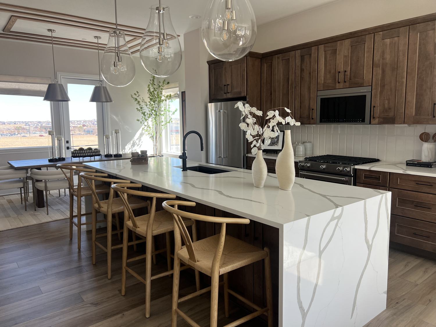 Kitchen with a quartz island, dark wood cabinetry and a high desert view